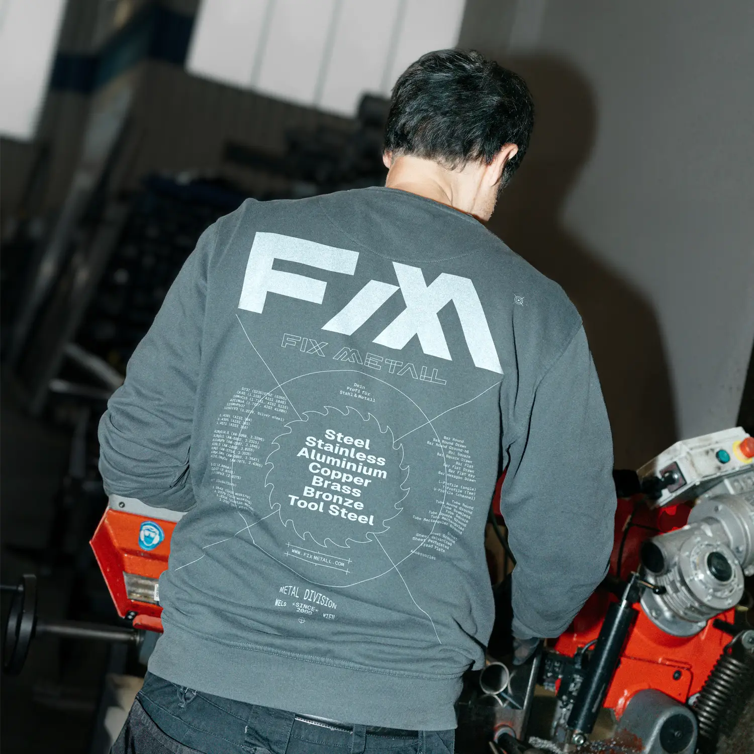 Person trägt blauen Pullover mit 'FIX METALL' Aufdruck.